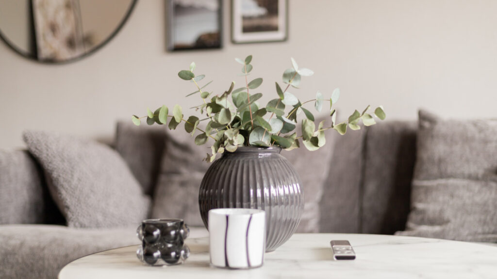 Vas med blommor på ett vardagsrumsbord.