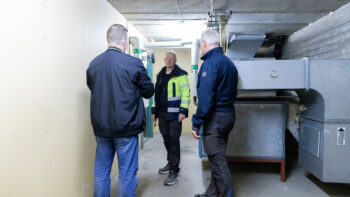 En grupp människor står i ett ventilationsrum.