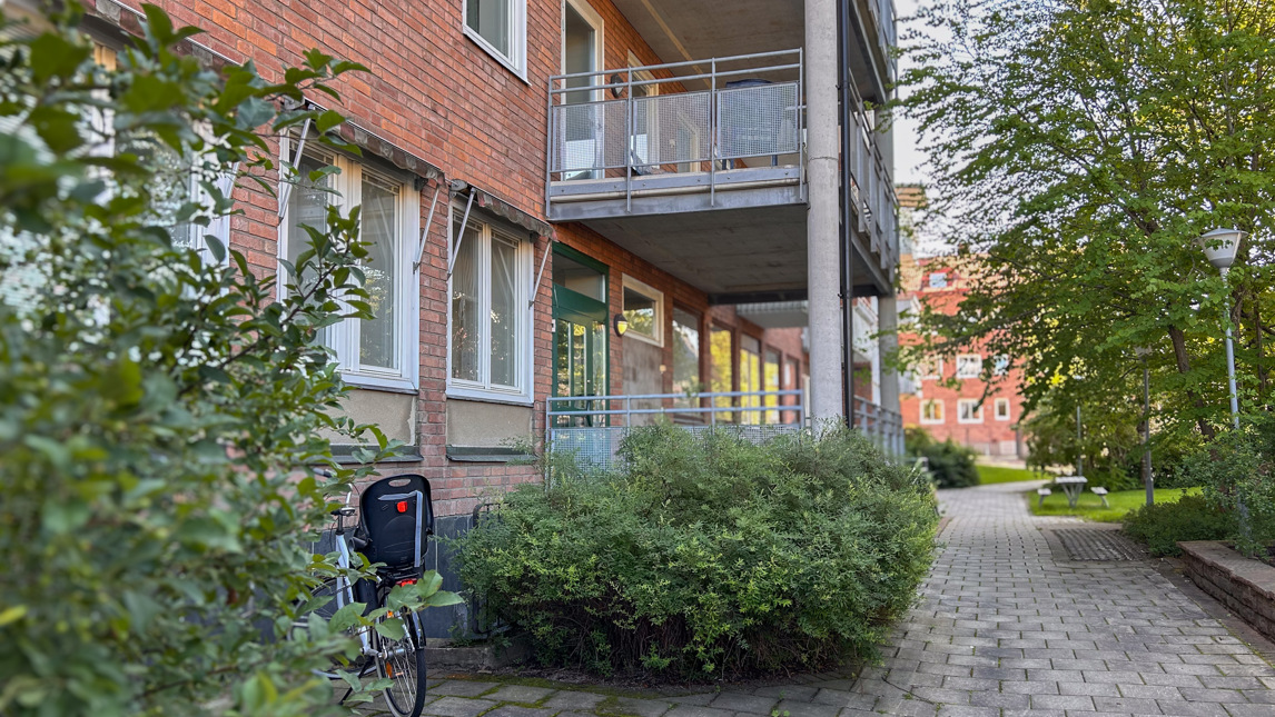 En cykel parkerad framför en tegelbyggnad.
