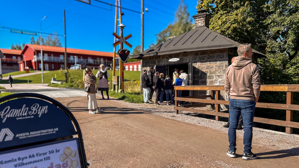 En grupp människor vid en gammal slaggstensbyggnad.