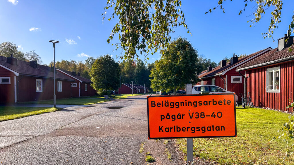 En gatuskylt framför en rad röda hus.