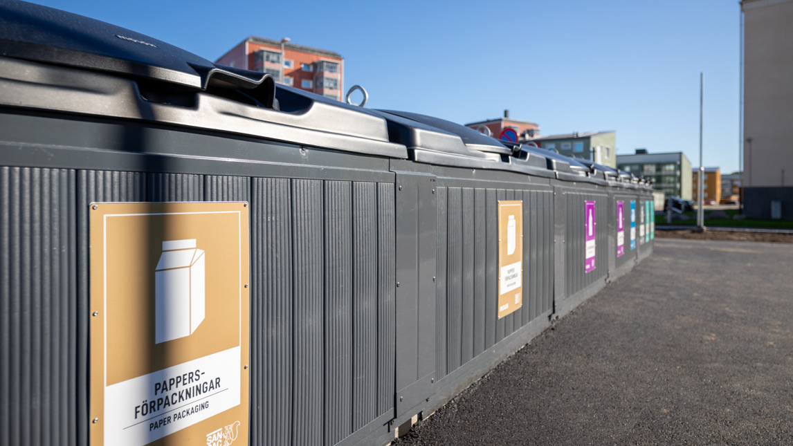 En rad fastighetsnära sorteringskärl.