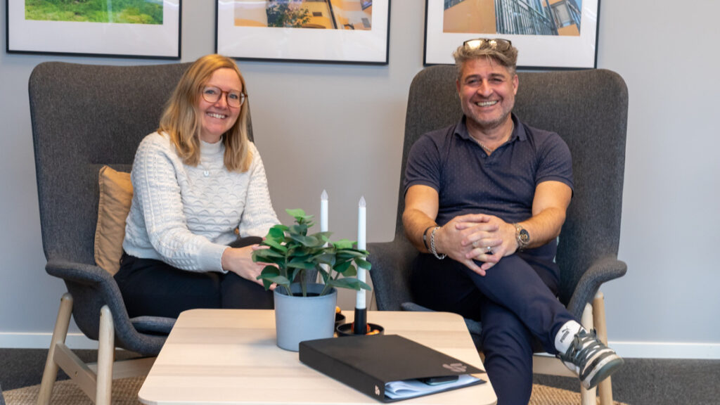 En man och en kvinna sitter i stolar på ett kontor.