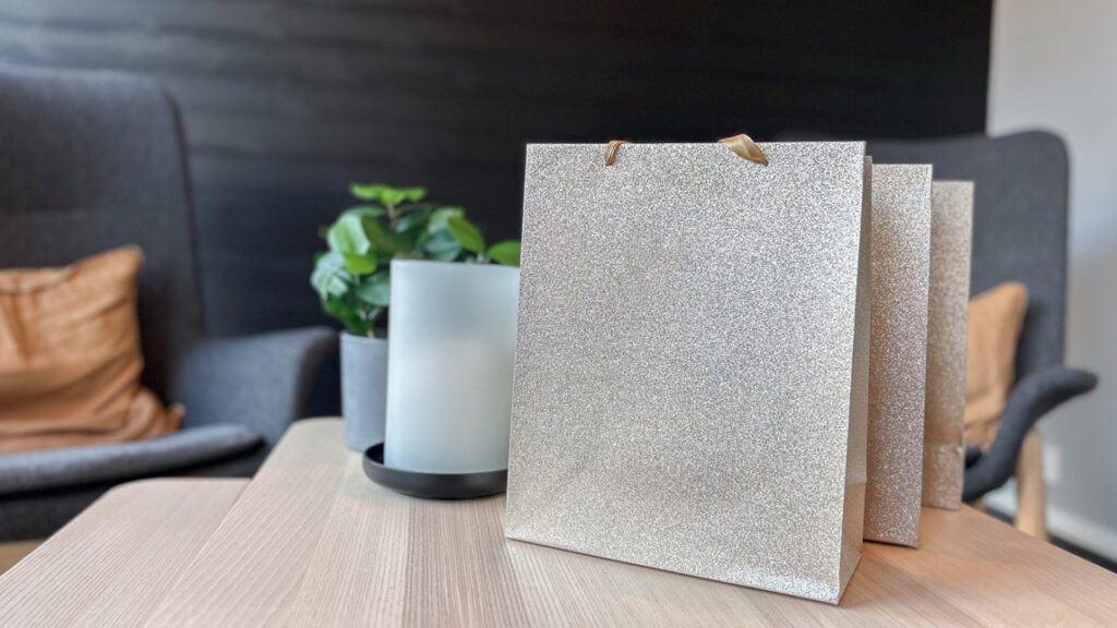 Tre presentpåsar som står på ett träbord.