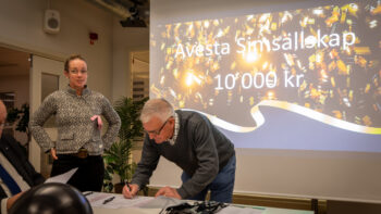 Två personer står vid en projektorduk.