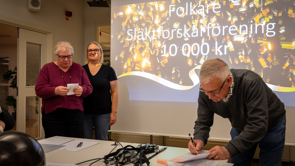 Två personer står vid en projektorduk.