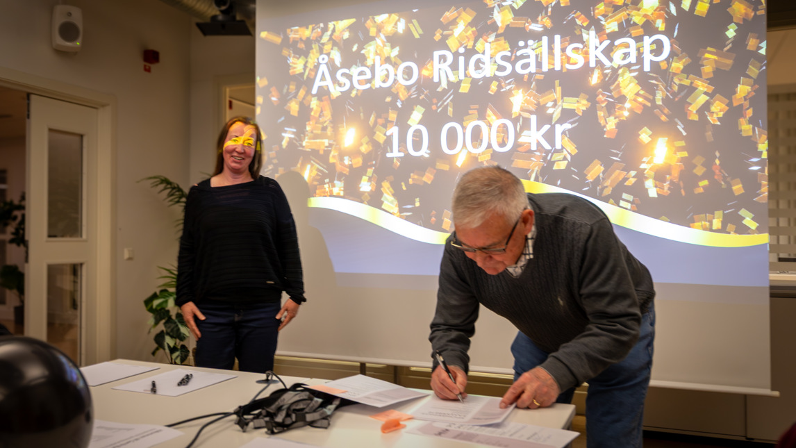 Två personer står vid en projektorduk.