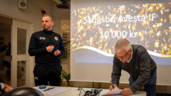 Två personer står vid en projektorduk.