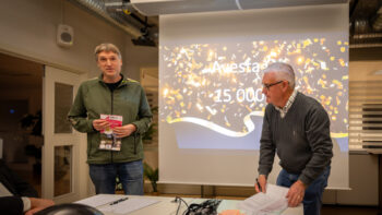 Två personer står vid en projektorduk.