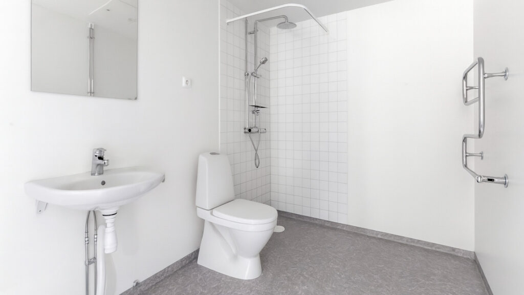 Ett badrum med toalett, handfat och dusch.