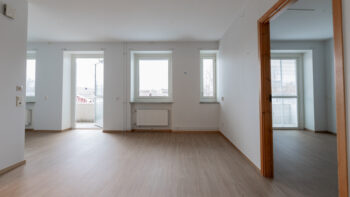 Ett tomt rum med vita väggar och trägolv.