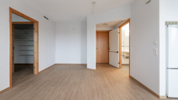 Ett tomt rum med vita väggar och trägolv.