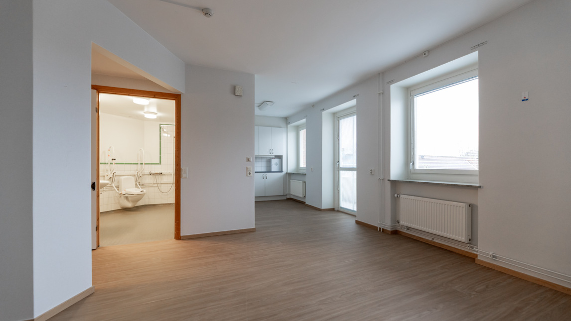 Ett tomt rum med vita väggar och trägolv.