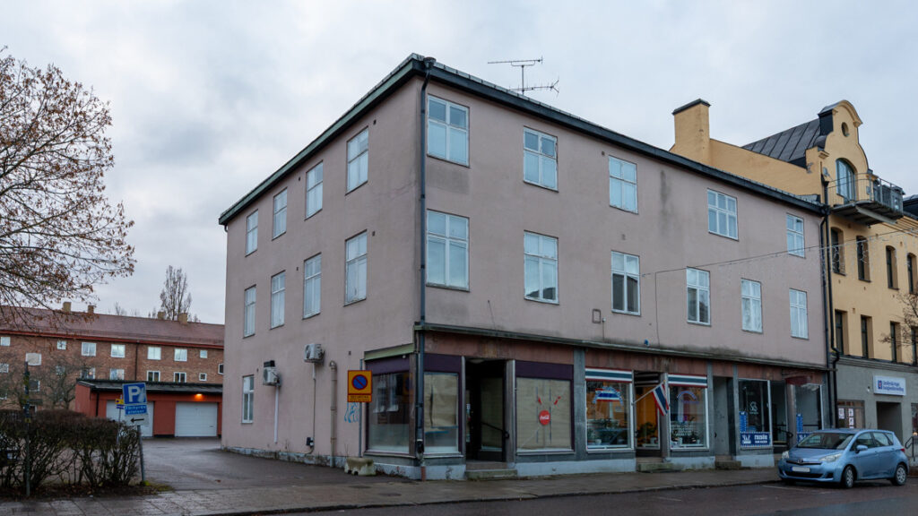 Ett rosa flerfamiljshus med lokaler på bottenvåningen.