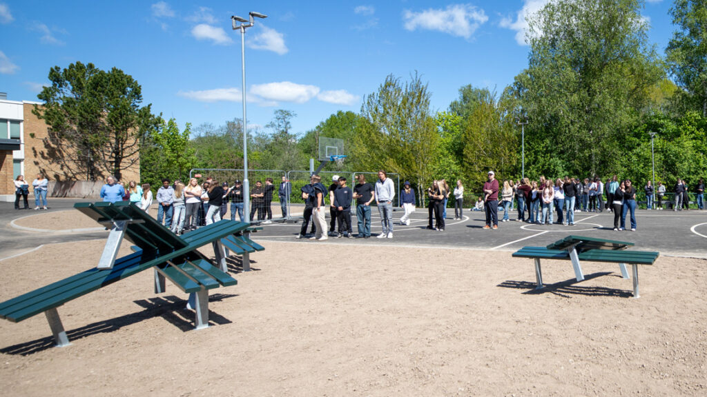 En grupp ungdomar står på en basketplan.